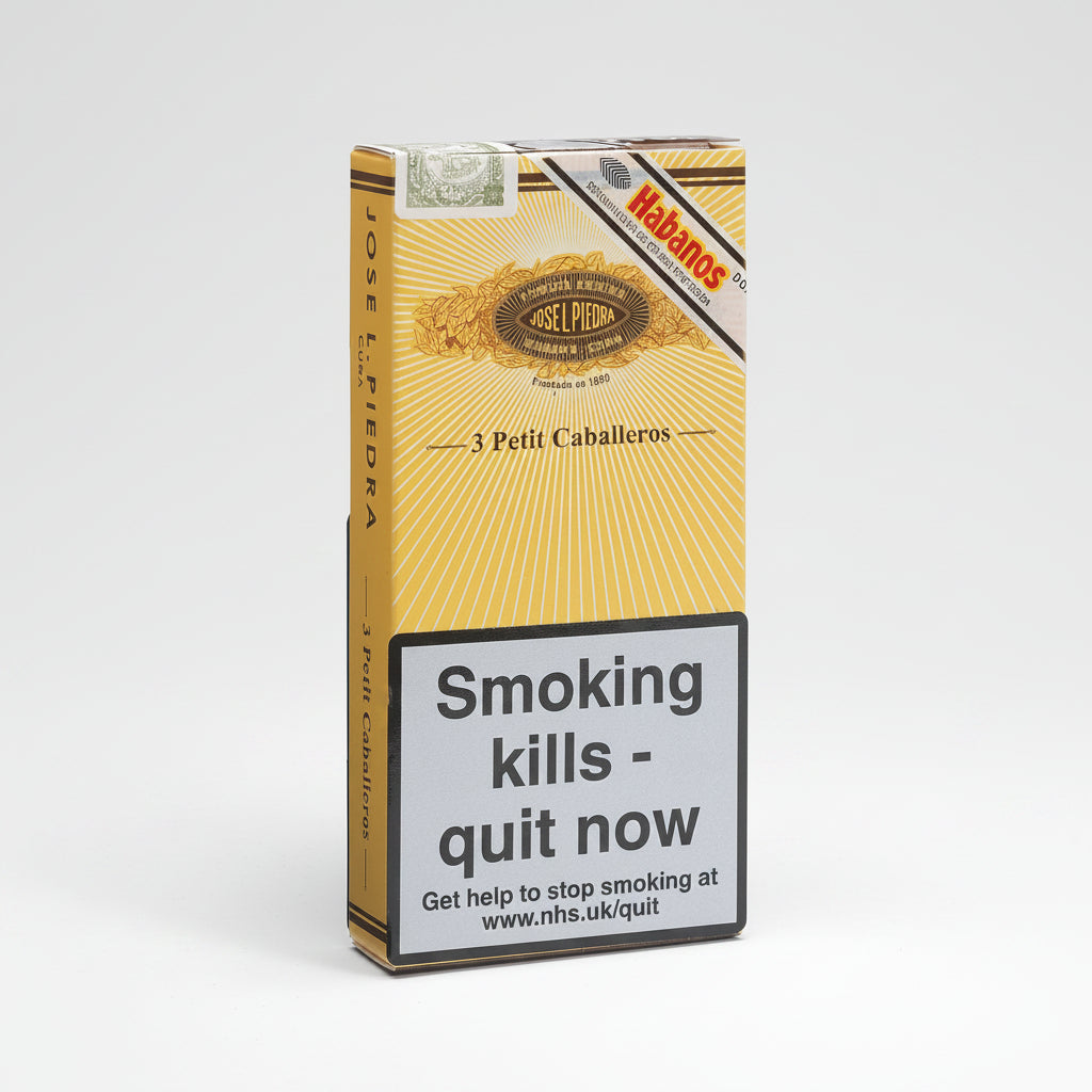 A pack of Habanos Jose L. Pedra Petit Caballeros cigarettes, featuring a yellow and gold sunburst design with a prominent grey warning label on the front.