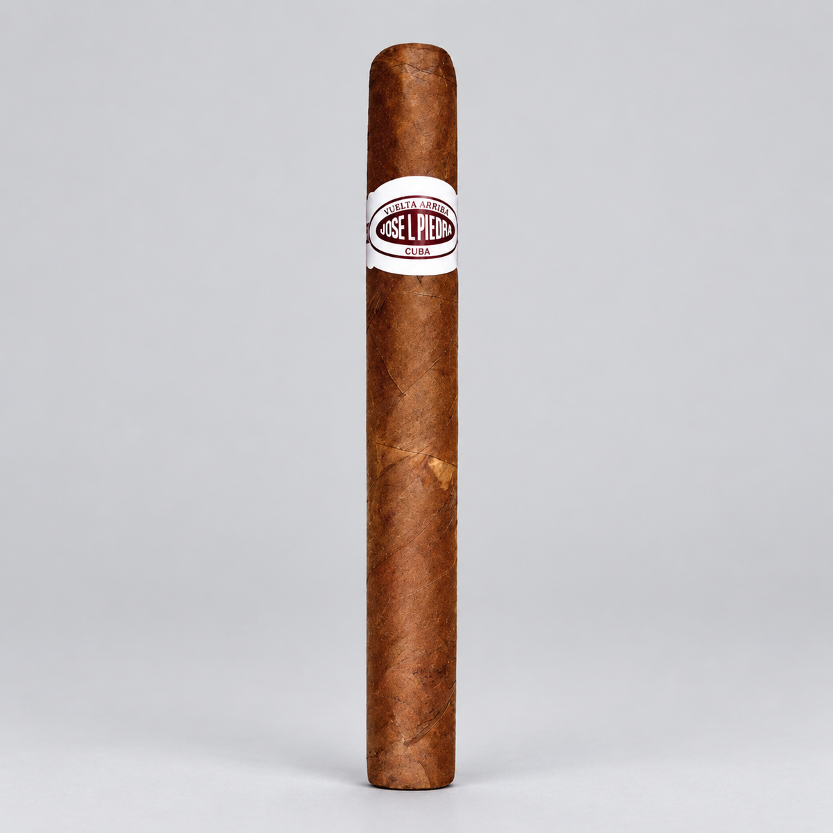 A single brown cigar standing upright on a light gray background, featuring a white band with the brand name 'Jose L. Pérez' in red and black text.