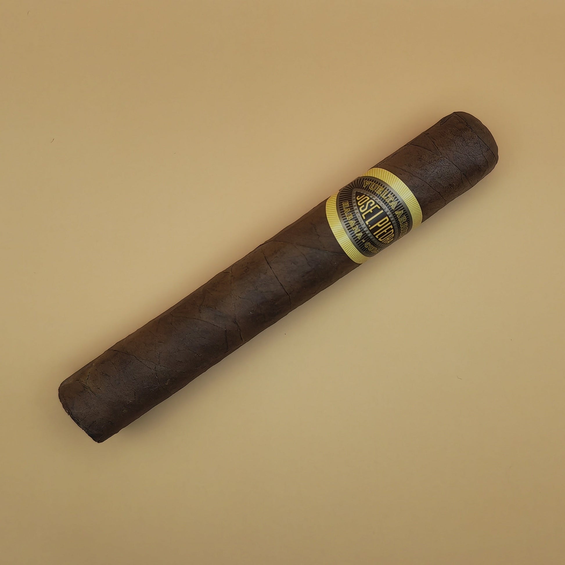 Cigar with a band on a beige background