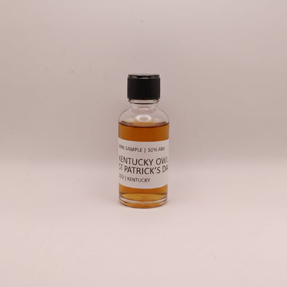 Small bottle of Kentucky Owl Whiskey with a label on a beige background