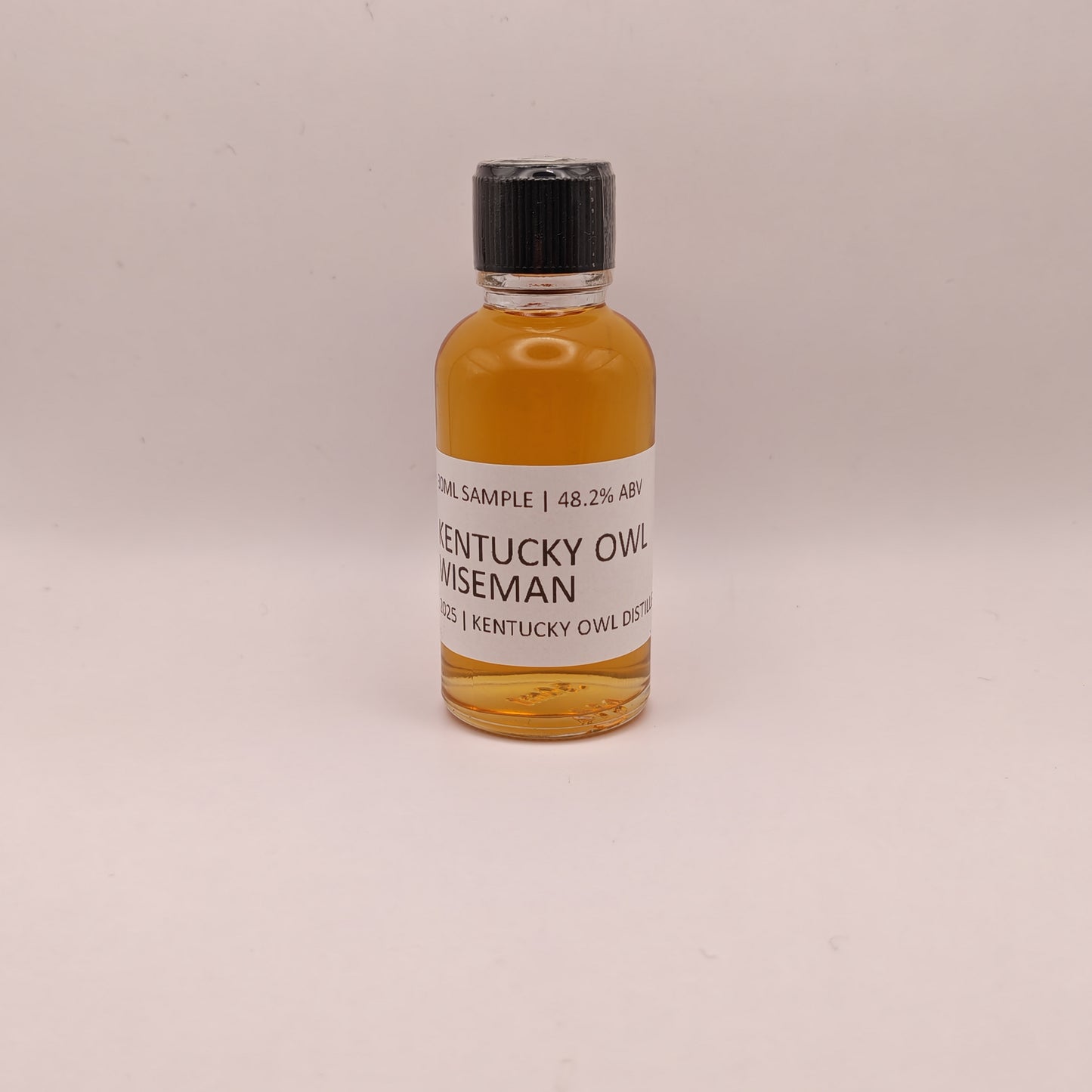 Small bottle of Kentucky Owl Wiseman on a light gray background
