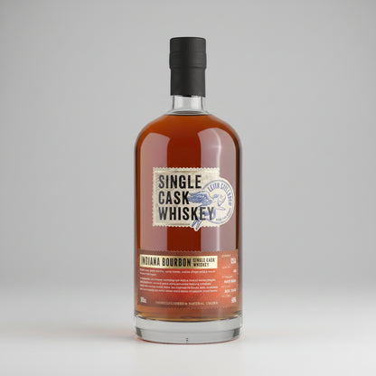 A bottle of Single Cask Whiskey Niagara Bourbon single cask whiskey, featuring an amber-brown liquid in a clear glass bottle with a black cap and a cream and orange label, set against a neutral gray background.