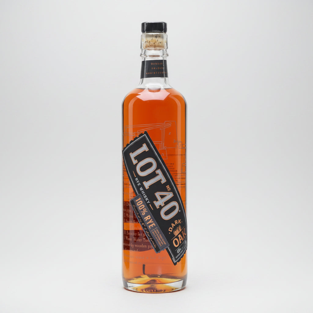 A bottle of Lot 40 Dark Rye 100% Rye Whiskey, showing the amber liquid inside a clear glass bottle with a black and orange label.