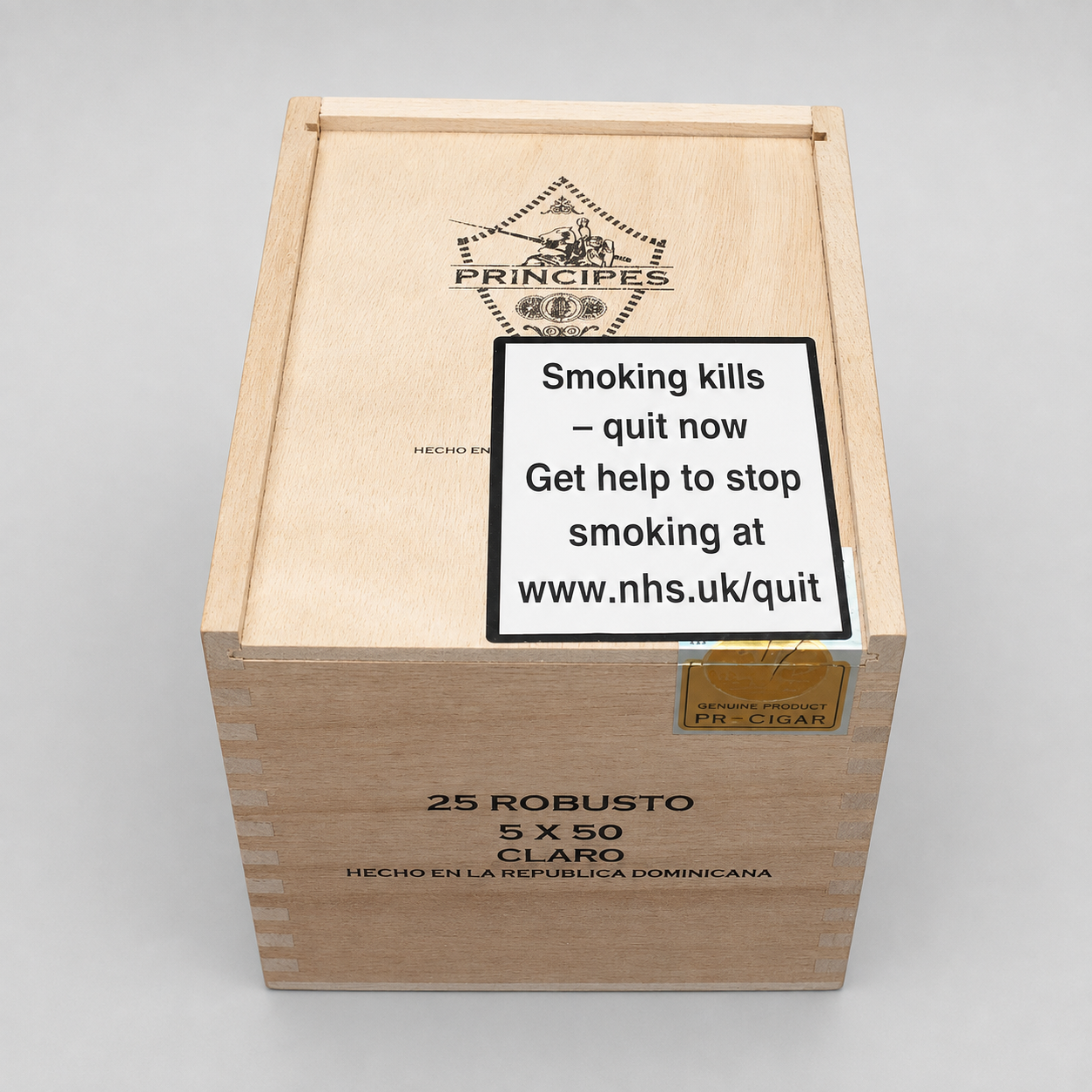A wooden cigar box labeled PRINCIPES 25 ROBUSTO 5 X 50 CLARO, with a prominent warning sign on the lid and a gold seal, photographed on a light gray background.
