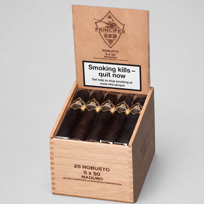 An open wooden cigar box on a light gray studio background, containing 25 cigars. The box lid is printed with the brand name Principes 2025 and a smoking-health warning label.