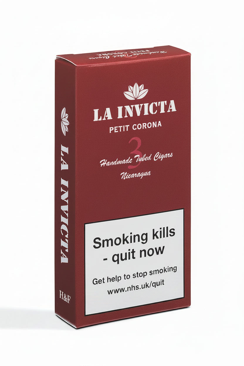 A red rectangular box of La Invicta Petit Corona handmade tobacco cigars, featuring white text and a prominent white warning label on the front, set against a plain white background.