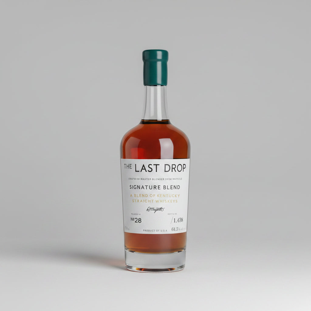 A bottle of The Last Drop Signature Blend single malt whisky displayed in a wooden presentation box, with its teal gift box, inner box, small bottle, and cork stopper arranged on a wooden surface.