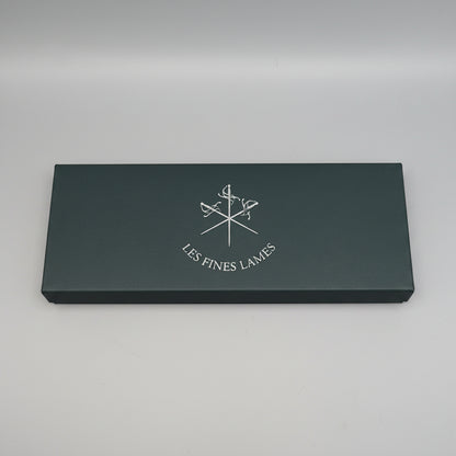 Black leather wallet with 'Les Fines Lames' logo on a brown leather background
