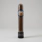 A single cigar in a clear cylindrical display tube with a black base, photographed against a light gray studio background. The cigar is dark brown, and the tube features a circular label reading 'Louis Martinez Silver Selection'.