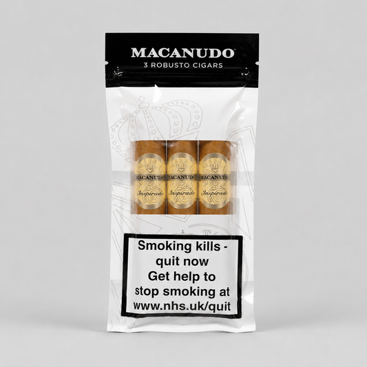 A package of Macanudo 3 Robusto Cigars on a light gray background. The white and black resealable pouch shows three cigars through a clear window, with a prominent smoking health warning label on the lower half.