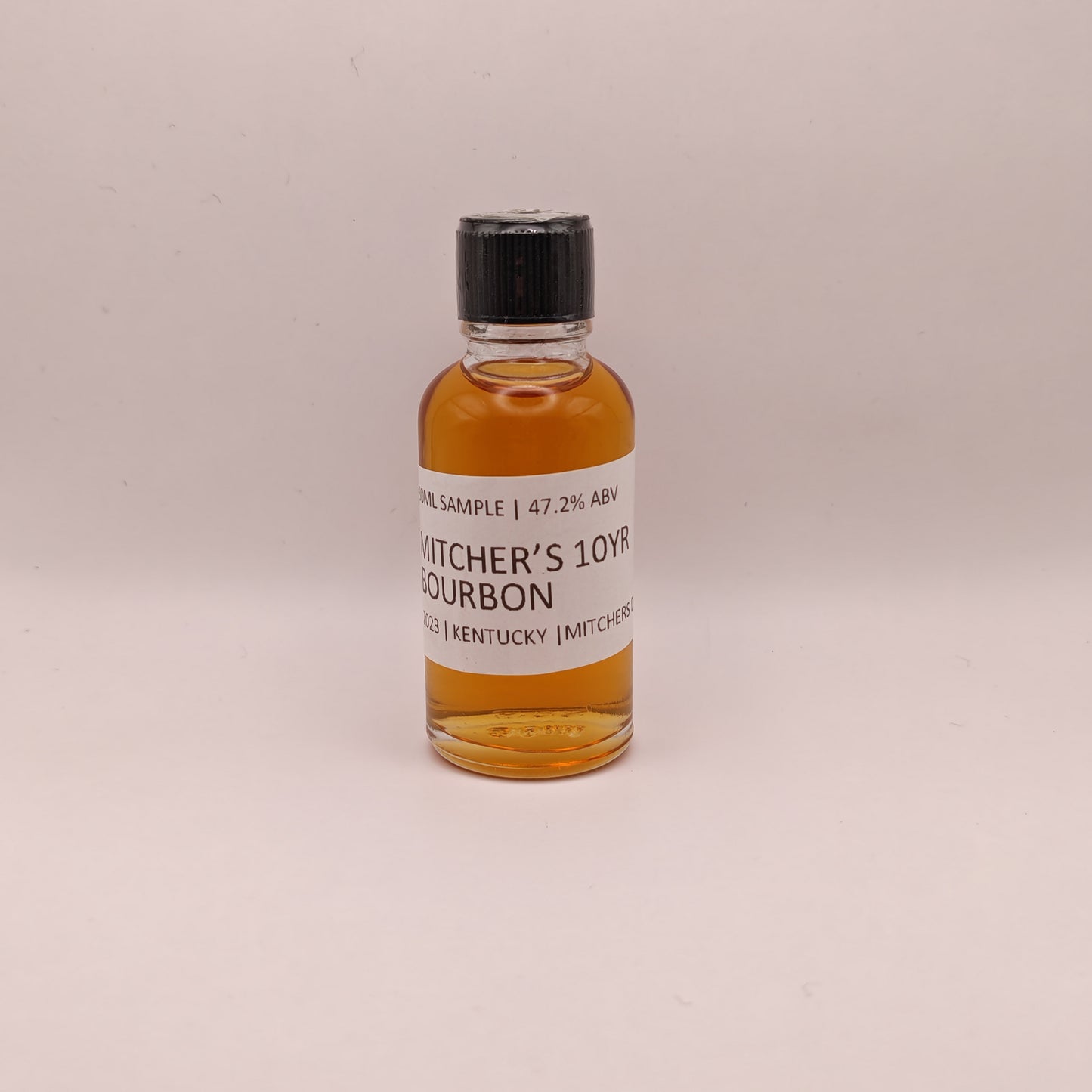 Small bottle of Michter's 10 Year Bourbon on a light beige background