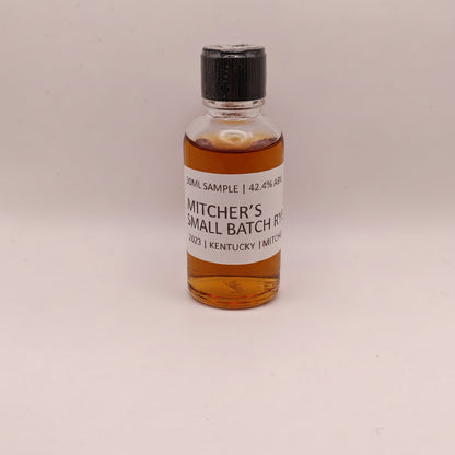 Small bottle of Mitcher's Rye whiskey sample on a beige background