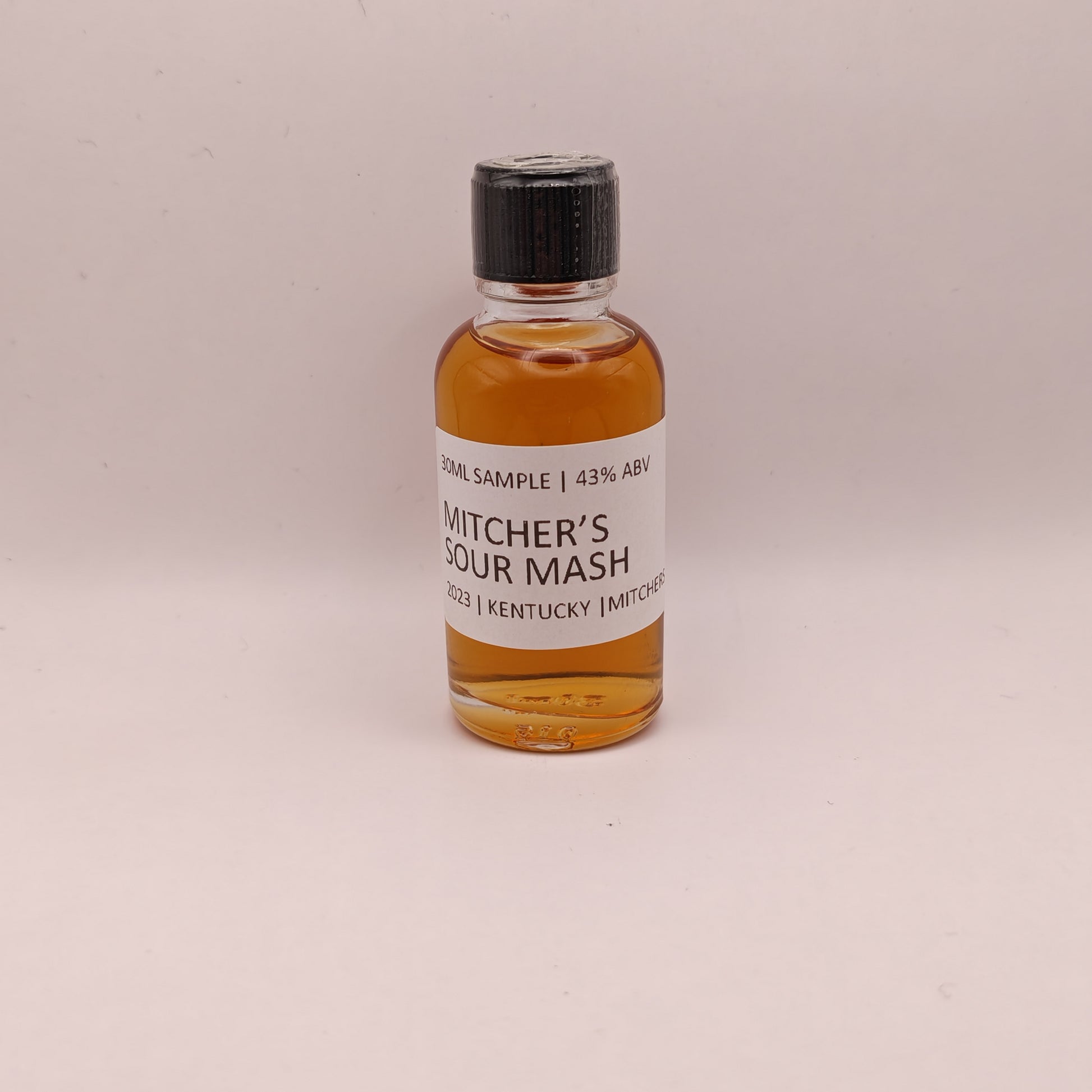 Small bottle of Mitcher's Sour Mash whiskey on a light background