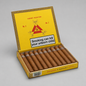 An open yellow and gold box of Montecristo No. 2 Habanero cigars, showing the interior with rows of brown cigars and the inside lid with the brand logo and a smoking warning label, set against a neutral gray background.