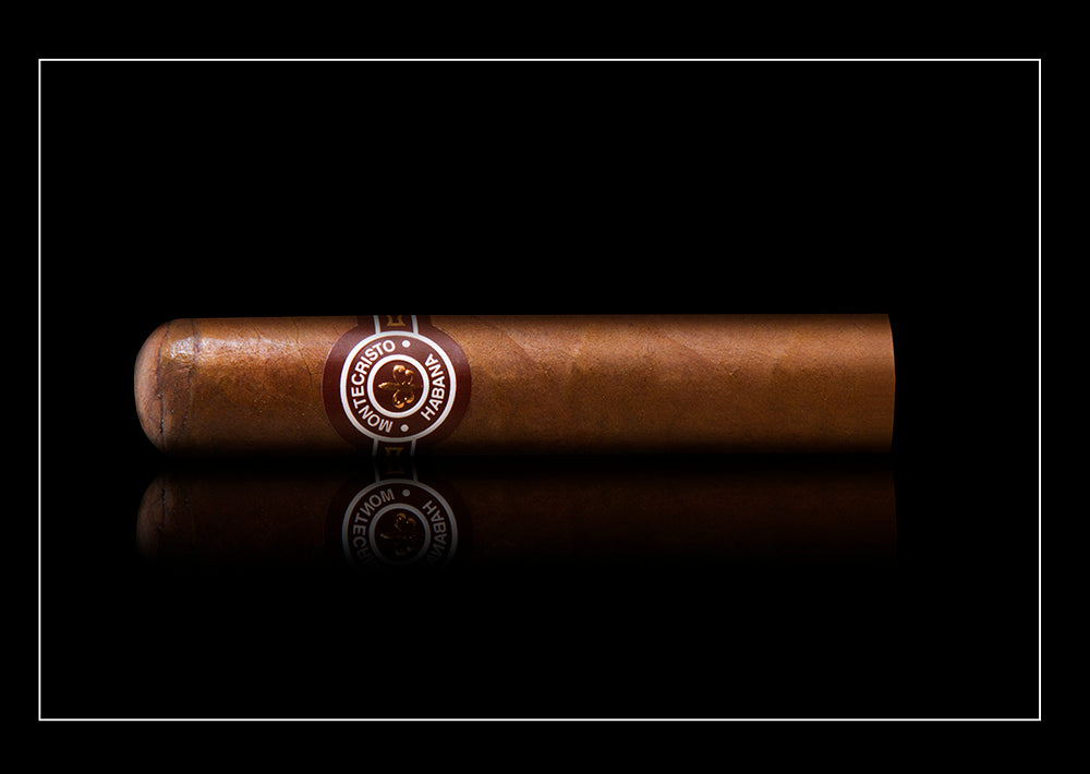 A single brown cigar with a circular silver and black band reading 'Cigarrito de la Hacienda', positioned horizontally against a solid black background with a subtle reflection below.