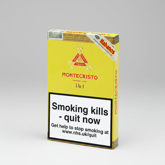 A pack of Montecristo Habanos cigars on a plain white background. The packaging is primarily yellow with a large white warning label on the front that reads 'Smoking kills - quit now' and includes the NHS website.