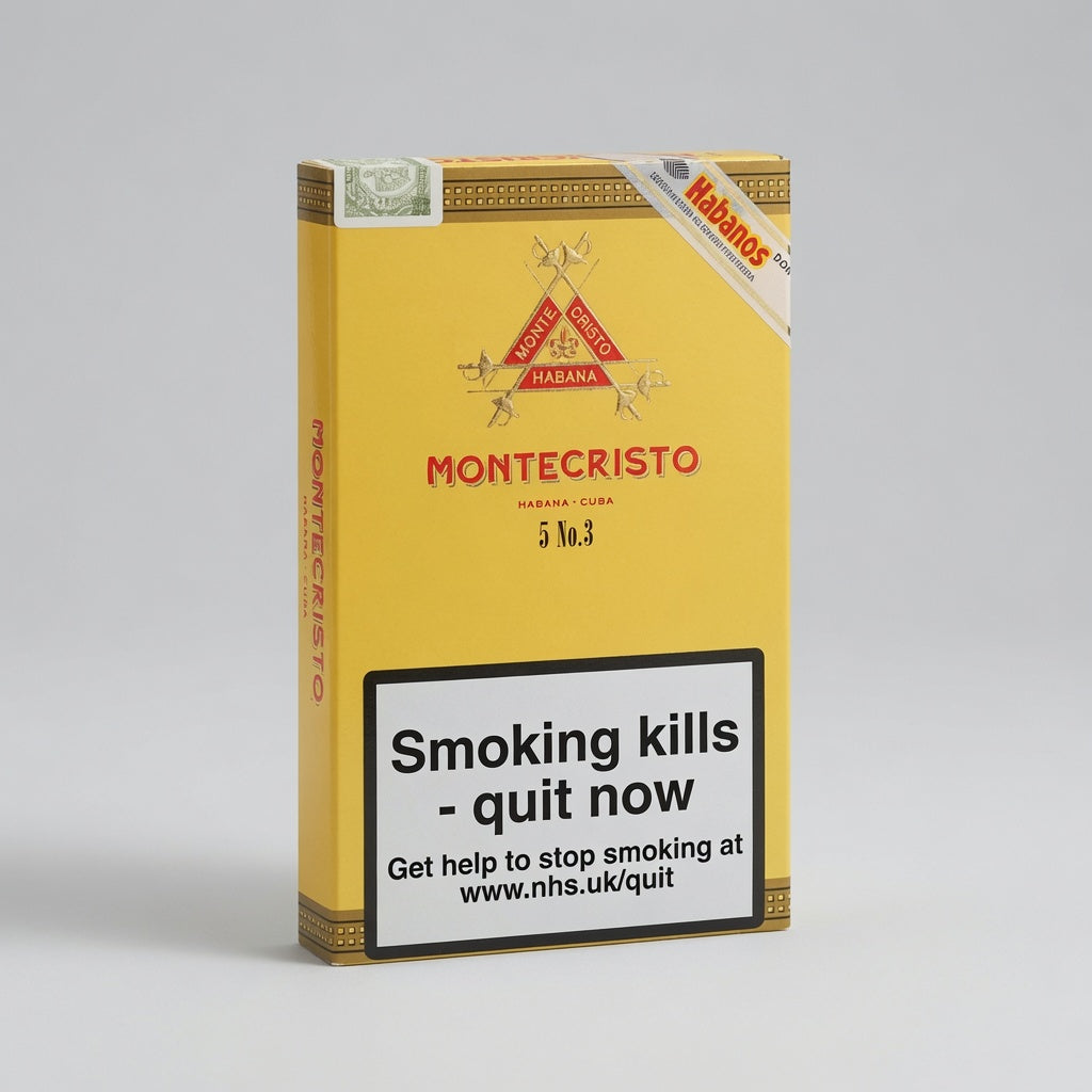 A Montecristo 3 No. 3 cigars pack in yellow packaging with a prominent smoking-health warning label on the front, photographed on a light gray studio background.