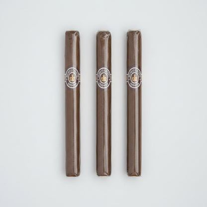 A single Montecristo Haban cigar in its clear plastic wrapper, showing the brown tobacco body and the circular Montecristo logo band.