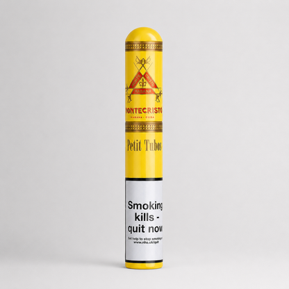A single Montecristo Petit Tubo cigar in its original paper wrapper, standing vertically against a light gray studio background. The wrapper is bright yellow with red and gold printed details and a white health warning label near the bottom.