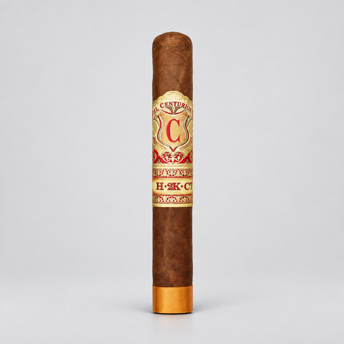 A single brown cigar standing upright on a light gray background, featuring a cream and red band with gold detailing and a gold foot.