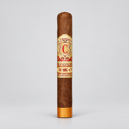 A single brown cigar standing upright on a light gray background, featuring a cream and red band with gold detailing and a gold foot.