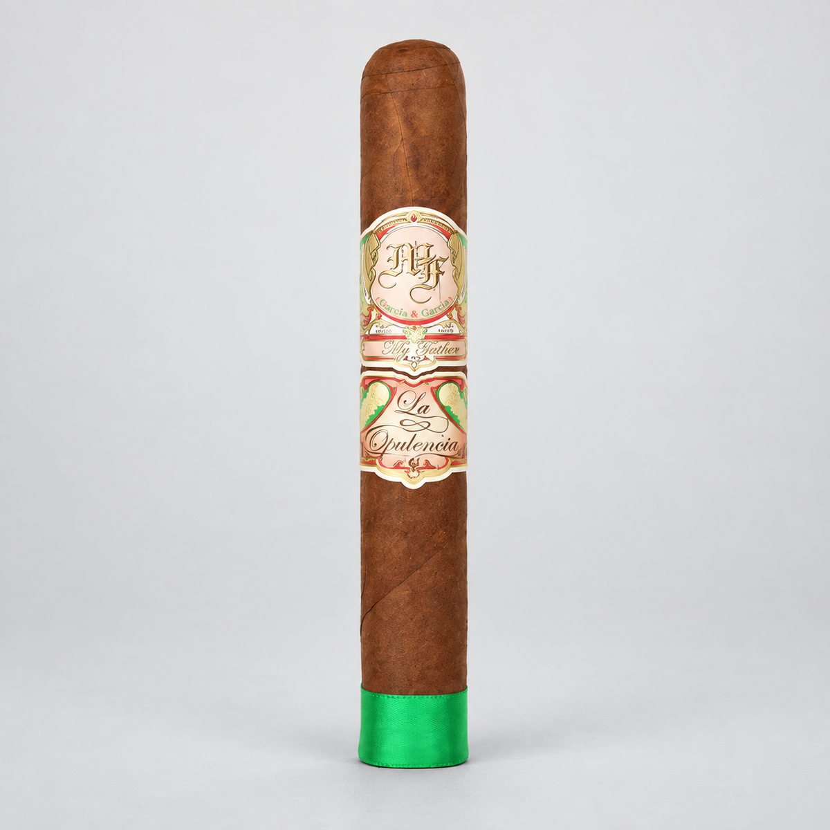 A single brown cigar standing upright on a light gray background, featuring a decorative cream and red band with green leaf illustrations and a bright green tip.