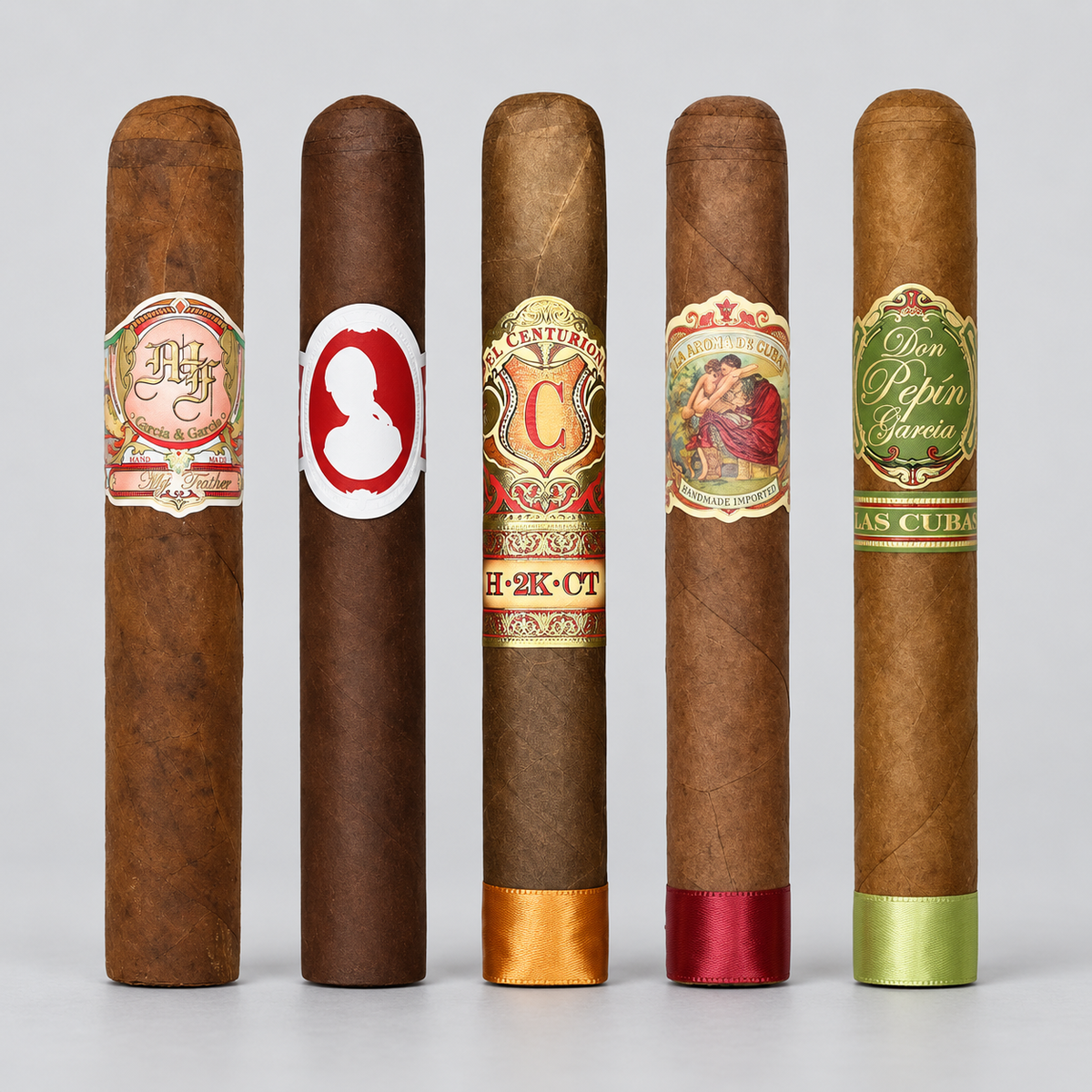 Five cigars standing upright in a row against a light gray studio background, each with a decorative paper label and a satin band at the base in different colors.