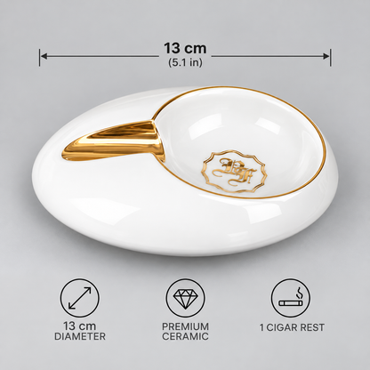 White ceramic cigar rest with gold trim and a gold crest emblem, shown on a light gray background with dimension and feature callouts indicating 13 cm diameter and 1 cigar rest.