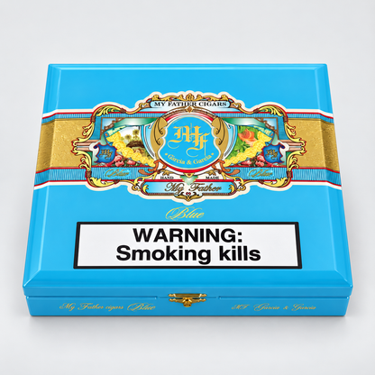 A bright blue cigar box with ornate gold, red, and white decorative artwork across the top and a large white warning label reading 'WARNING: Smoking kills' on the front. The visible brand text includes 'My Father Cigars' and 'Rumiantes'.