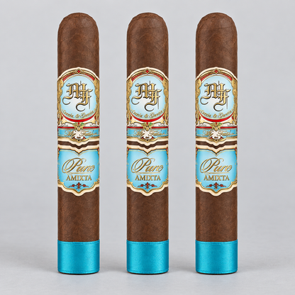 Three brown cigars standing upright side by side on a light gray background. Each cigar has a decorative label with gold, blue, and white details, and a bright blue band near the bottom.