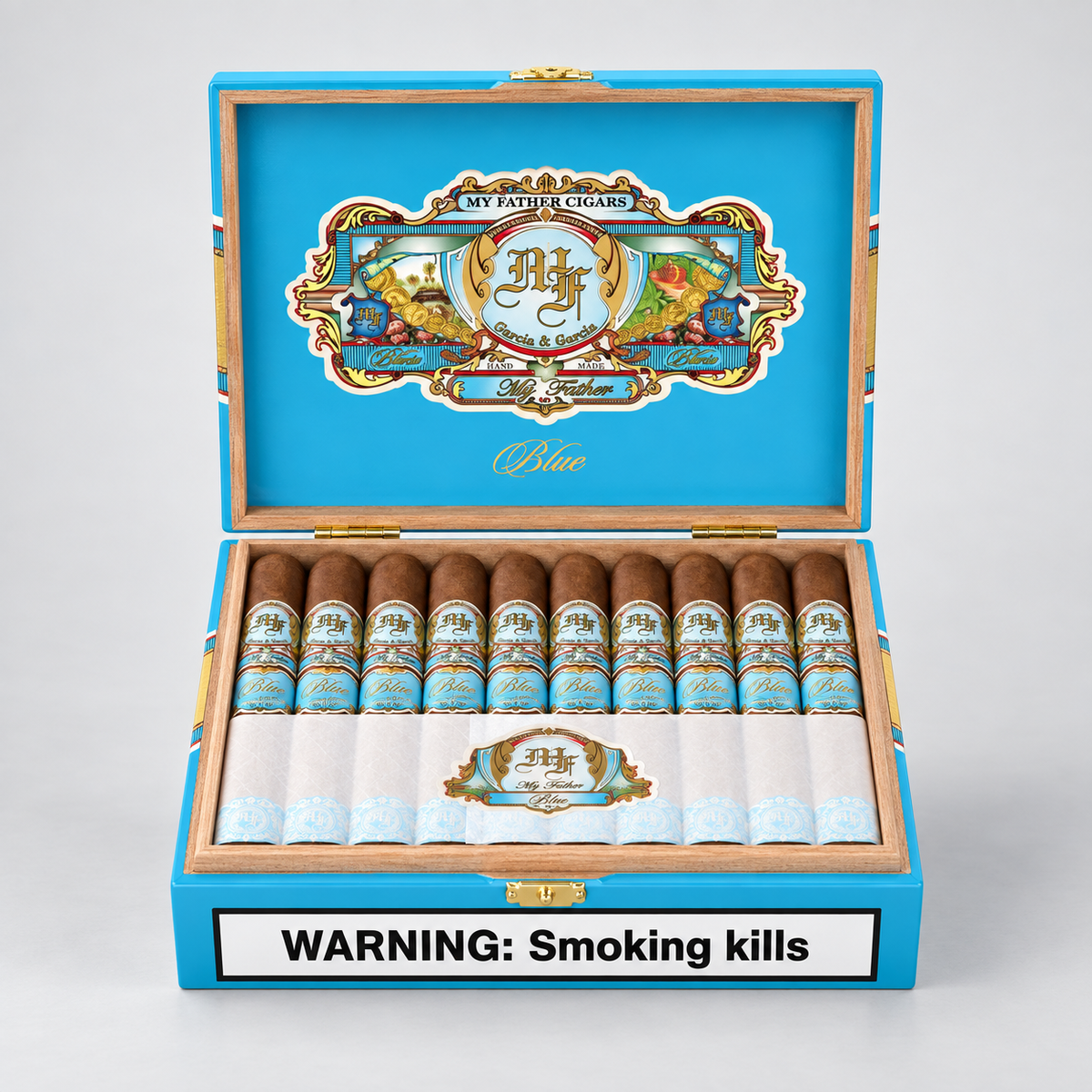 An open blue cigar box displaying multiple cigars inside, with a large decorative crest on the inner lid and a white warning label reading 'WARNING: Smoking kills' on the front. The cigars have brown bodies with blue and gold bands, and the box is set against a light gray background.