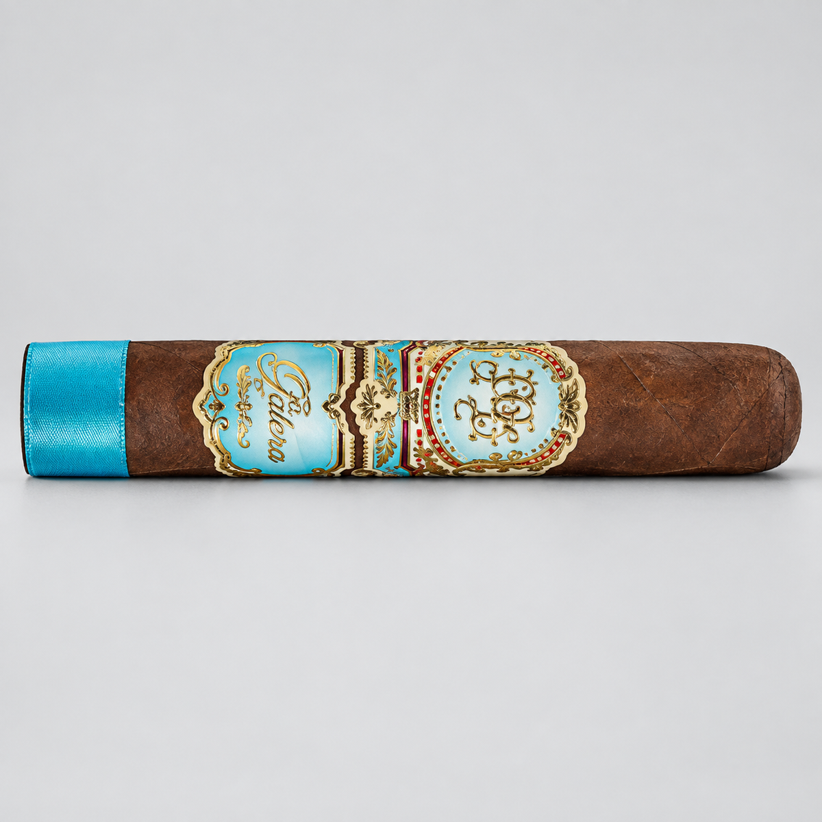 A single brown cigar shown horizontally on a light gray background, featuring a turquoise blue band with gold detailing and the brand name 'Pabellon' visible.