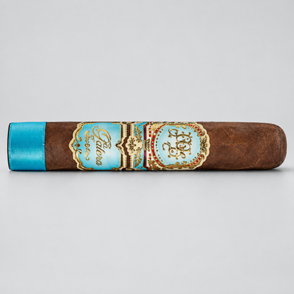 A single brown cigar shown horizontally on a light gray background, featuring a turquoise blue band with gold detailing and the brand name 'Pabellon' visible.