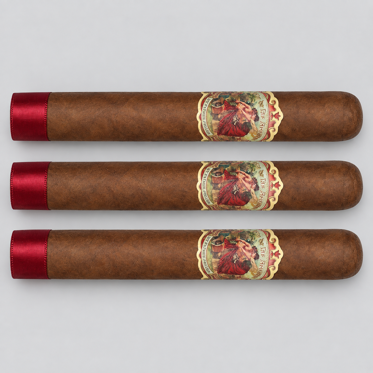 Three brown cigars arranged horizontally on a light gray background, each with a red satin tip and a decorative circular band featuring a portrait.