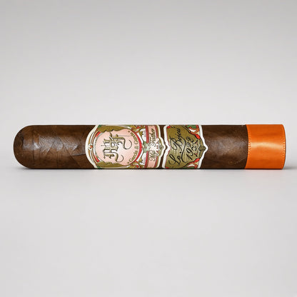 A single dark brown cigar with a detailed multicolor paper band and a bright orange tip, displayed horizontally on a light gray background.