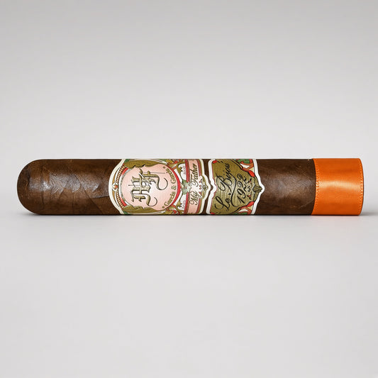 A single dark brown cigar with a detailed multicolor paper band and a bright orange tip, displayed horizontally on a light gray background.