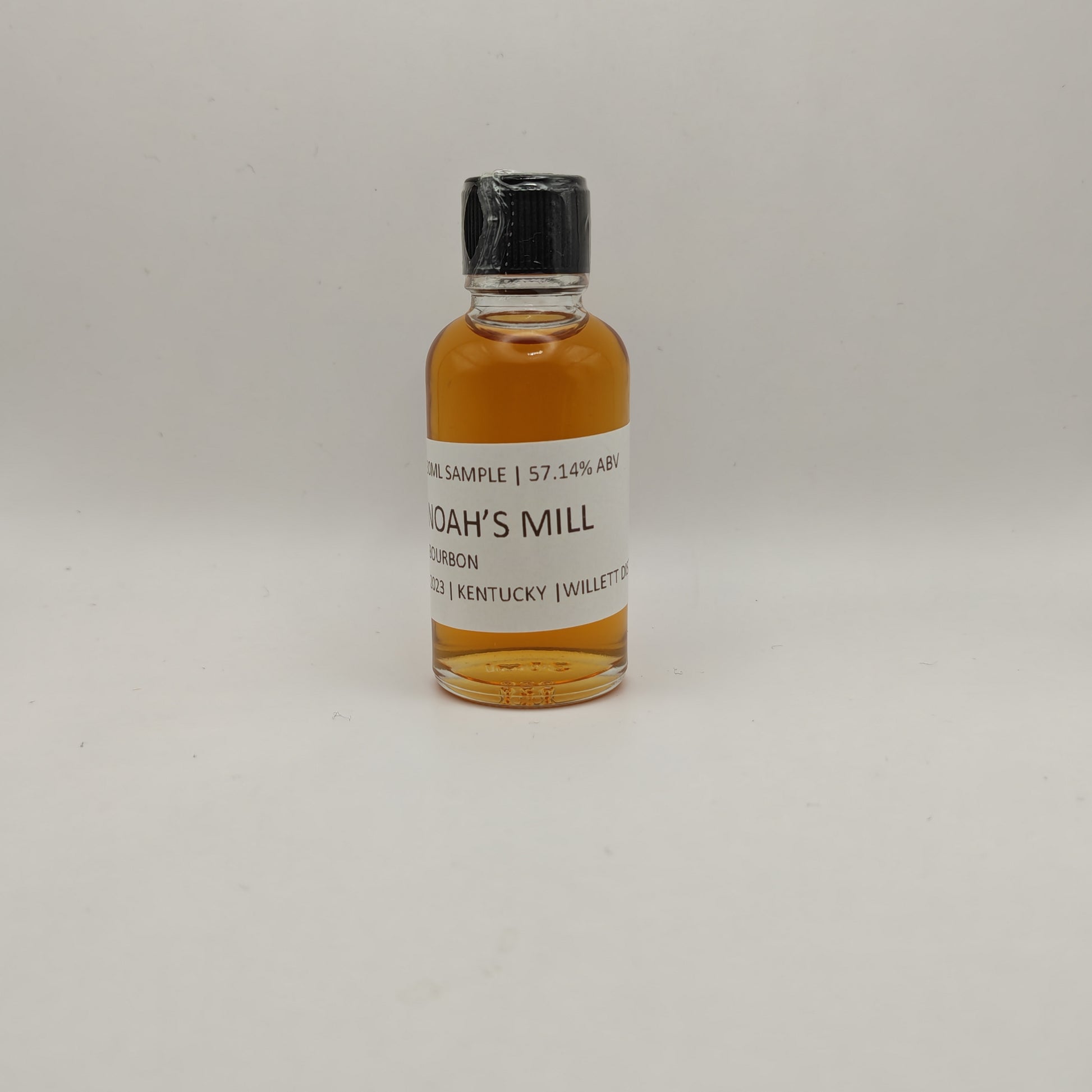 Small bottle of Noah's Mill bourbon sample on a white background