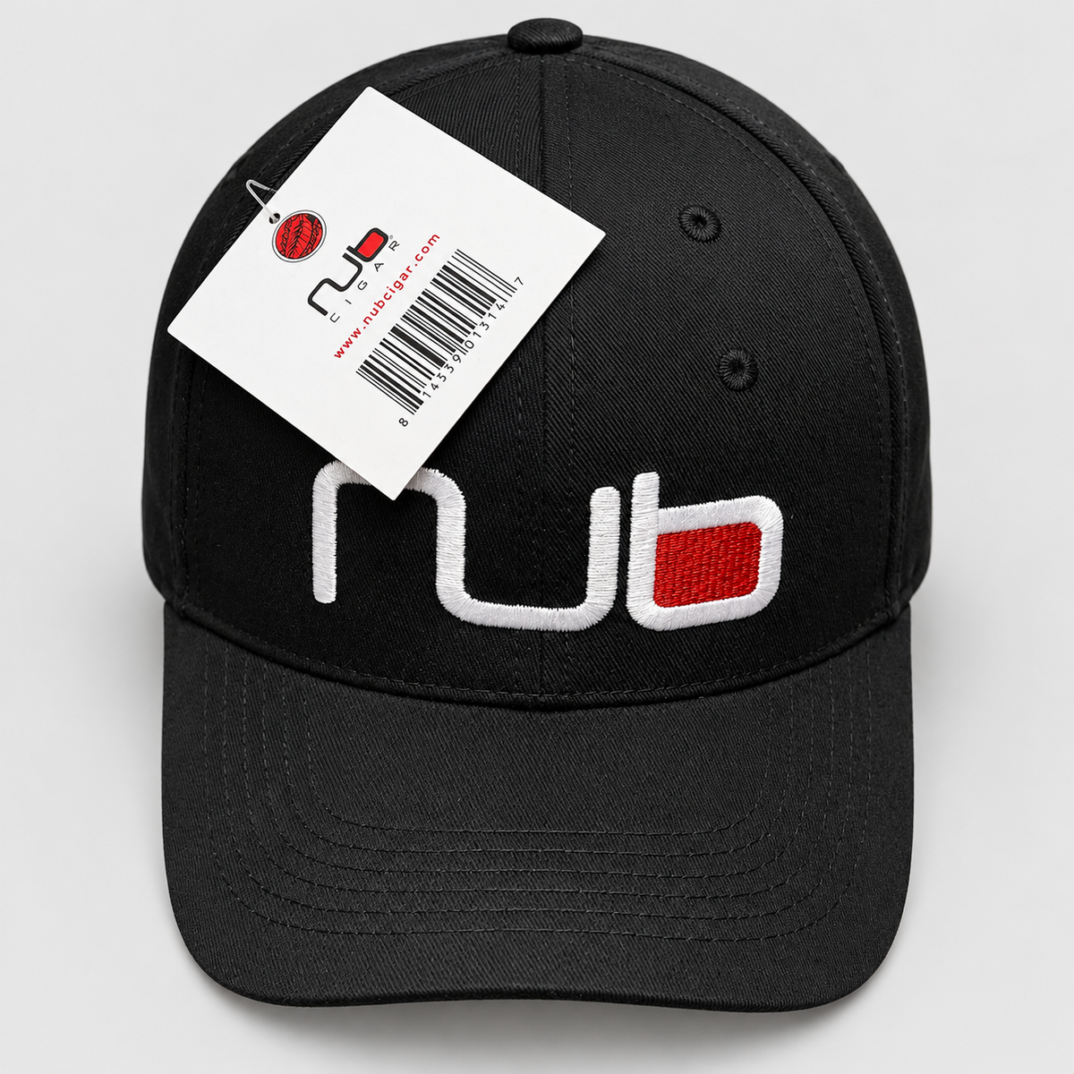 A black baseball cap with a white and red embroidered 'nub' logo on the front, featuring a white hangtag with a barcode and the nub logo, photographed on a light gray background.