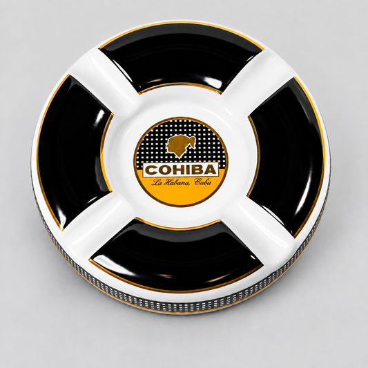 A round black and white divided cigar ashtray with gold trim, featuring a central logo for 'COHIBA La Habana Club'.