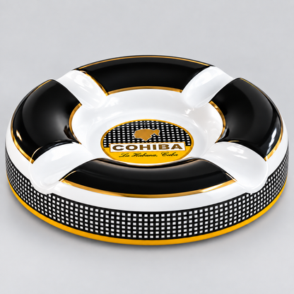 A circular black and white ashtray with gold trim, featuring a central logo for 'COHIBA The Premium Cigars' and a black-and-white checkered band around the lower edge, photographed on a light gray background.