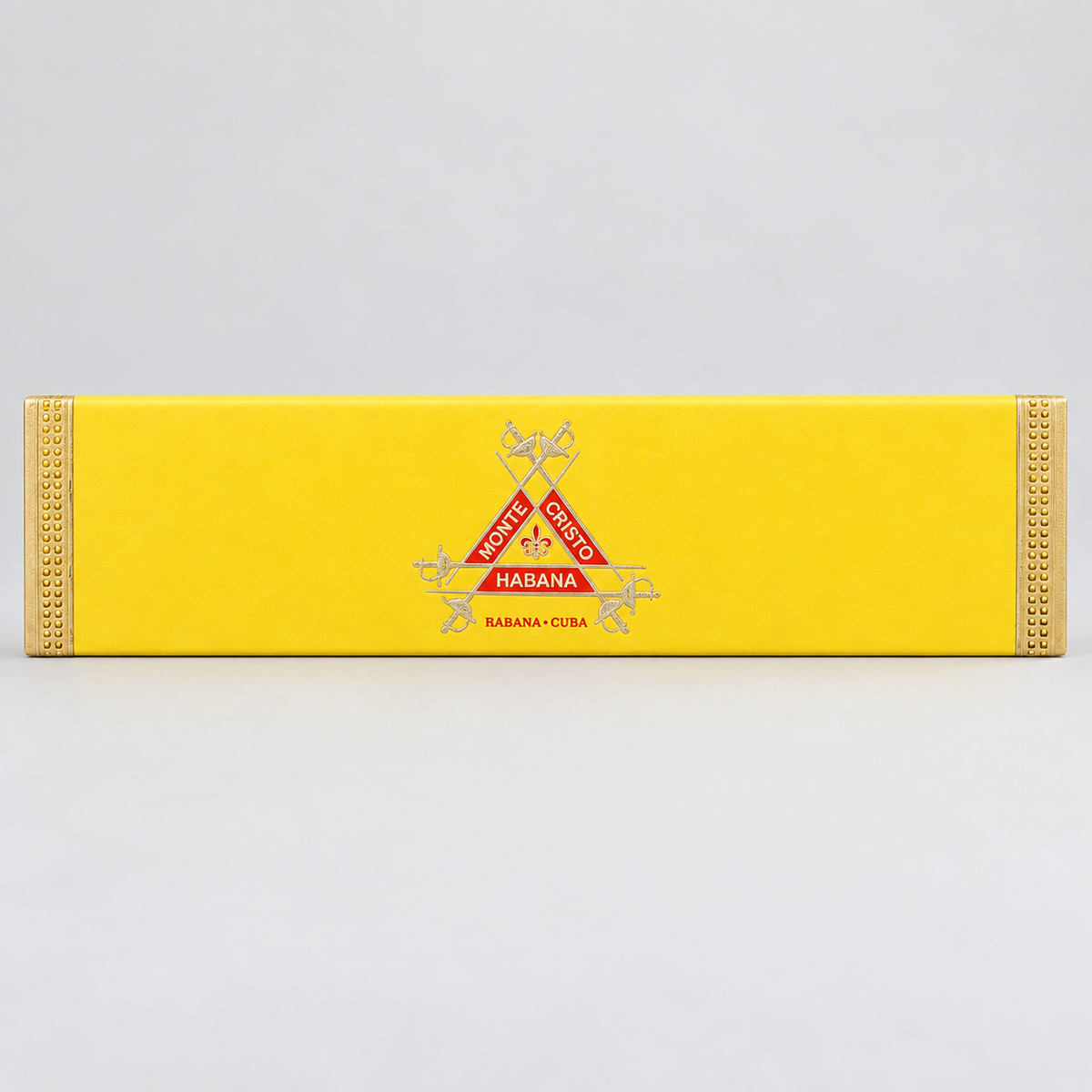 A long, narrow yellow cigar box with decorative gold-toned trim and a central red and silver Cuban Habana insignia, photographed on a light gray background.