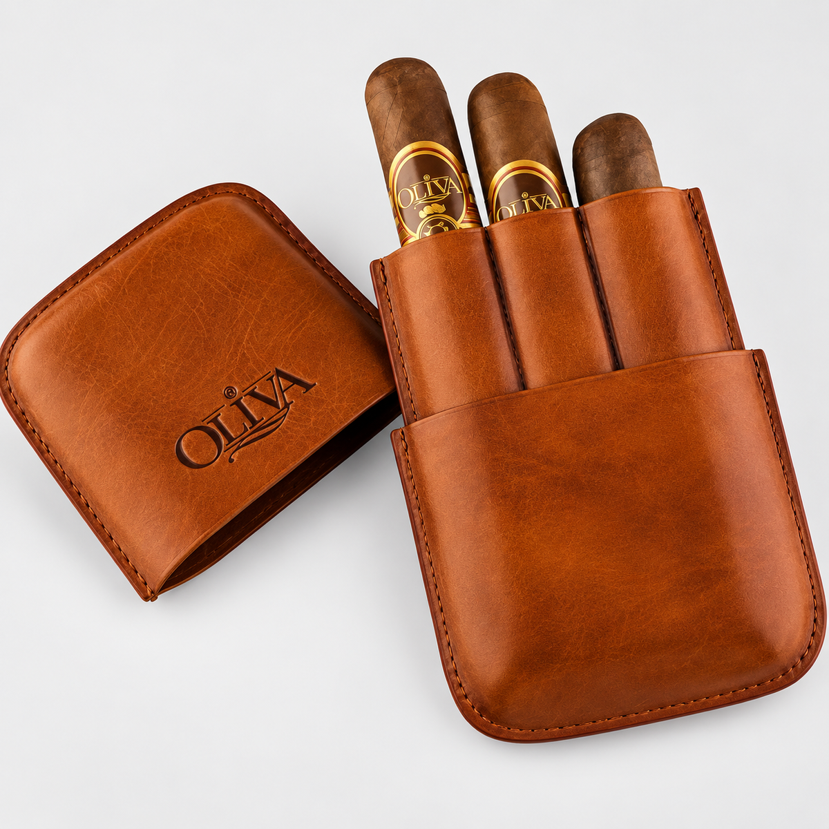 A brown leather cigar case shown open with three cigars inserted. The case lid, placed to the left, is embossed with the brand name 'OLIVA'.