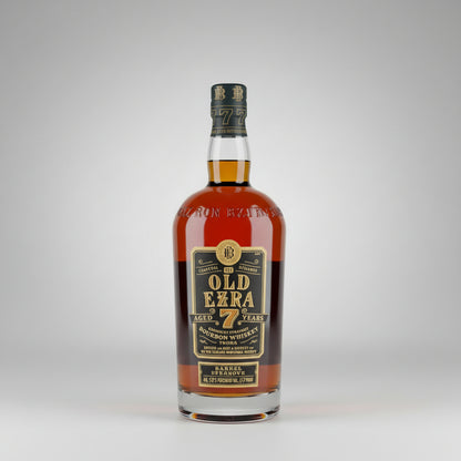 A bottle of Old Ezra 7 Years Bourbon Whiskey standing on a wooden surface against a plain light background.