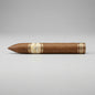 A single brown cigar with gold and cream bands, positioned horizontally on a light gray background.