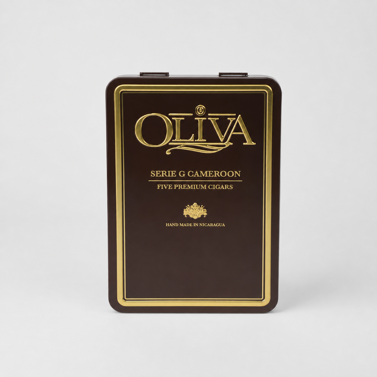 A dark brown metal tin box for Oliva Serie G Cameroón five premium cigars, featuring elegant gold foil lettering and borders, set against a clean light gray background.