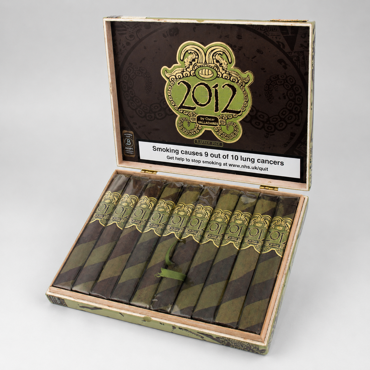 An open cigar box containing ten cigars, photographed on a light gray studio background. The box lid is open and displays a dark brown interior with a large gold and green '2012' emblem and a white health warning label.