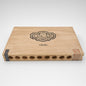 A rectangular wooden cigar storage box with a light natural wood finish, featuring a black engraved crest that reads 'The Oscar Valentino Habanco' and the word 'HABANCO' below it. The box has circular cutouts along the bottom edge and a decorative paper band on the right side, photographed on a clean white background.