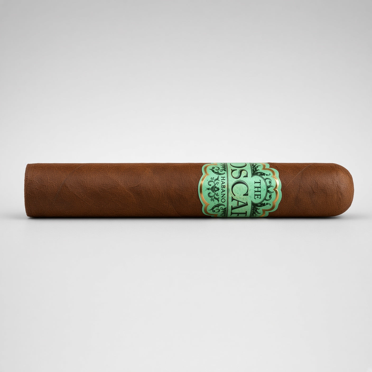 A single brown cigar with a green and gold band reading 'The Oscar Escobar', photographed horizontally against a light gray gradient background.