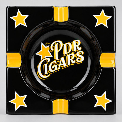 A square black ashtray with four yellow stars and yellow side indentations, featuring the 'PDR Cigars' logo in the center.