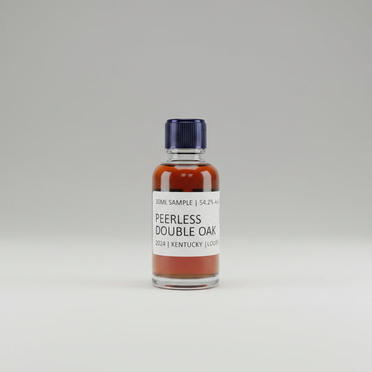 Bottle of Peerless Double Oak bourbon on a bar with other bottles in the background.